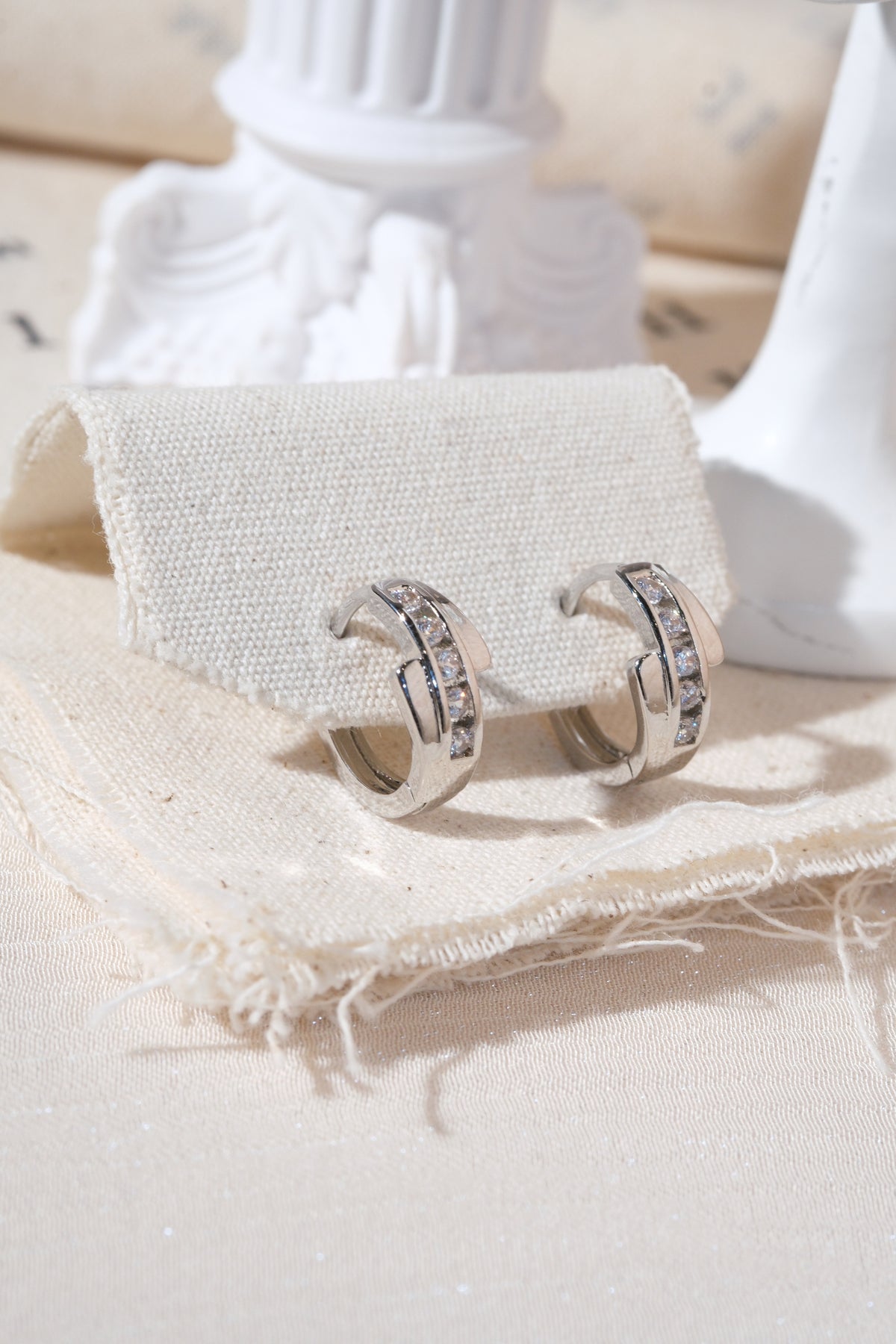Silver Crossover CZ Huggie Earrings — edited real product photo