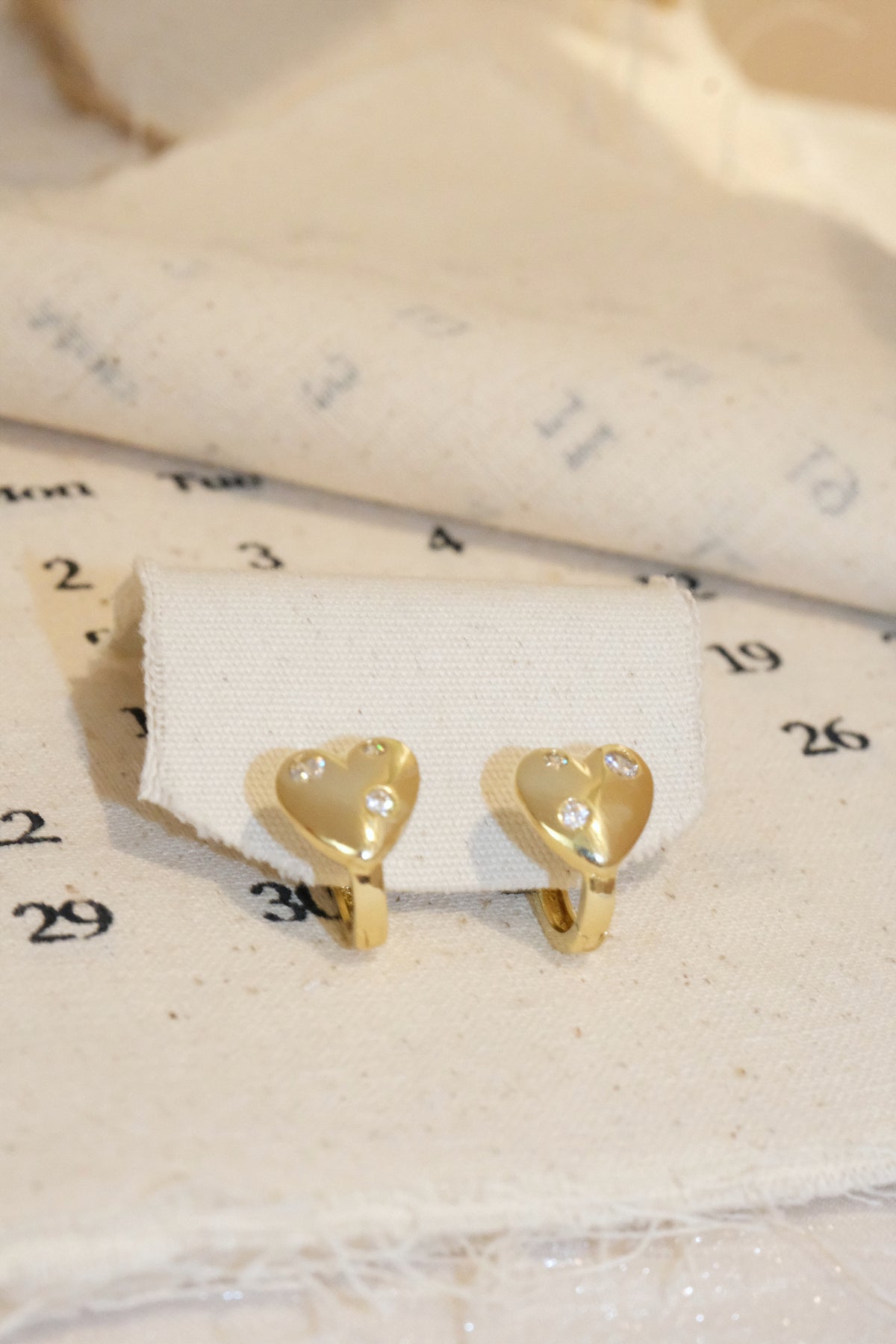 Gold Scattered CZ Heart Huggie Earrings — edited real product photo