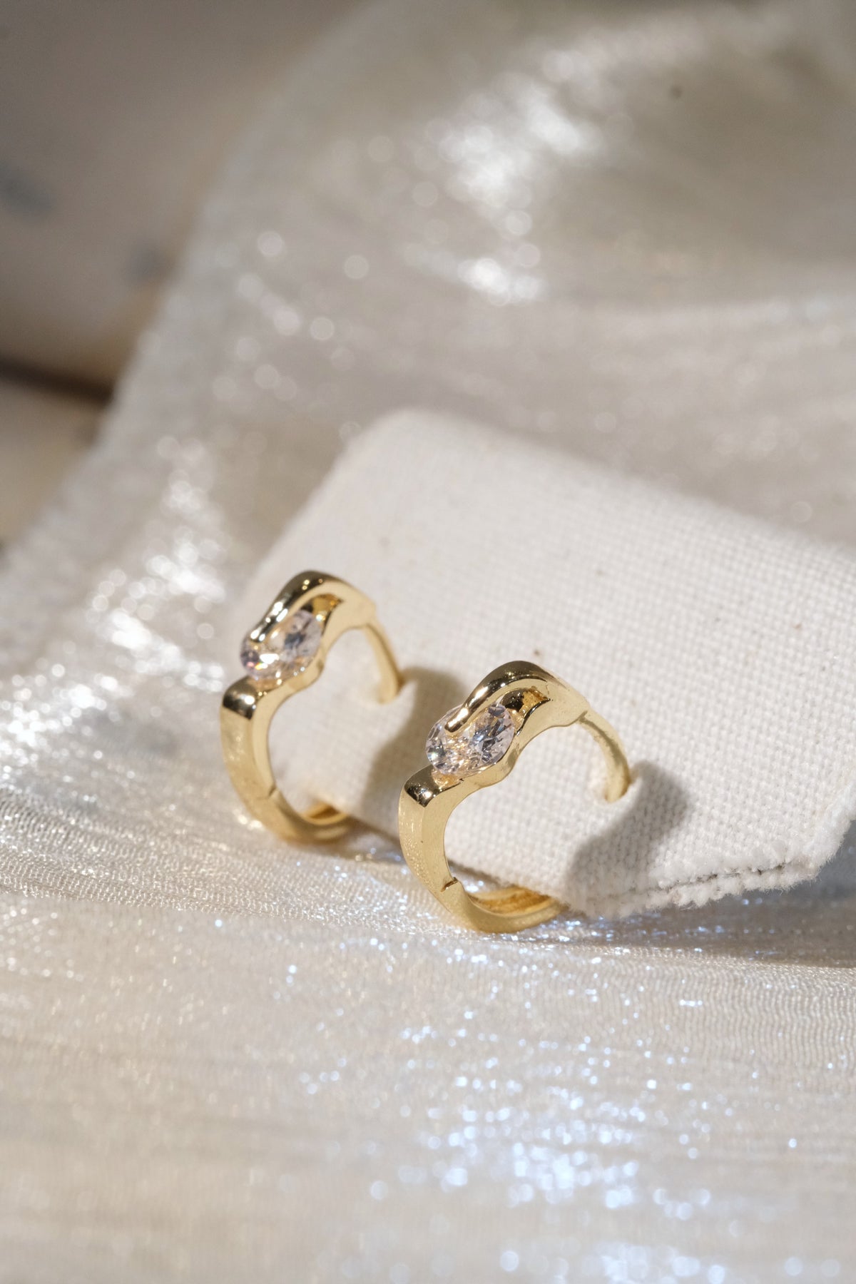 Solitaire CZ Huggie Earrings — Gold — edited real product photo