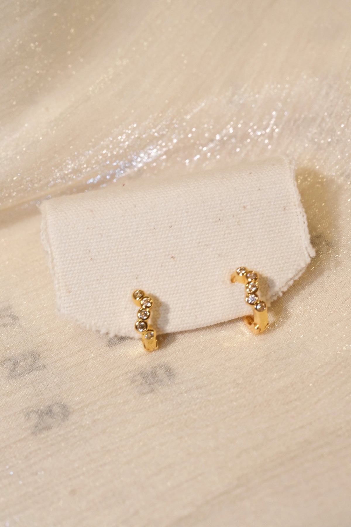 Five-Stone Bezel CZ Huggie Earrings — Gold — edited real product photo