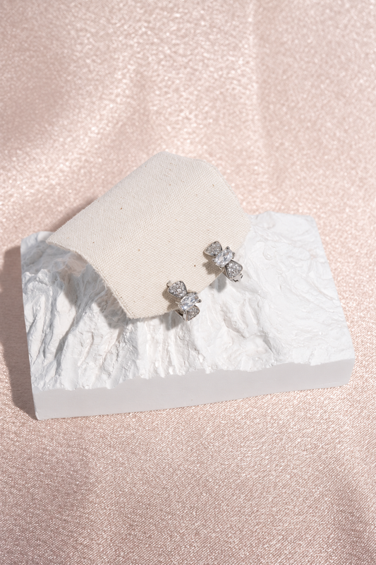 Silver Tone Bow Huggie Hoop Earrings in stainless steel, view 1