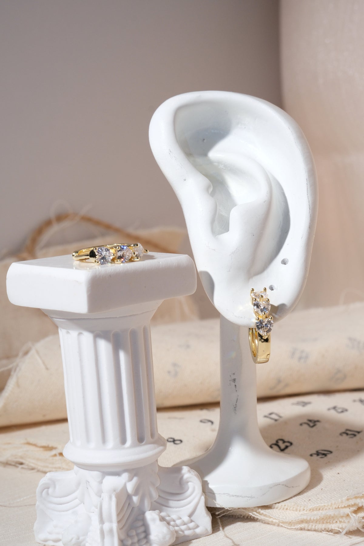 Gold Triple Heart CZ Huggie Earrings — edited real product photo