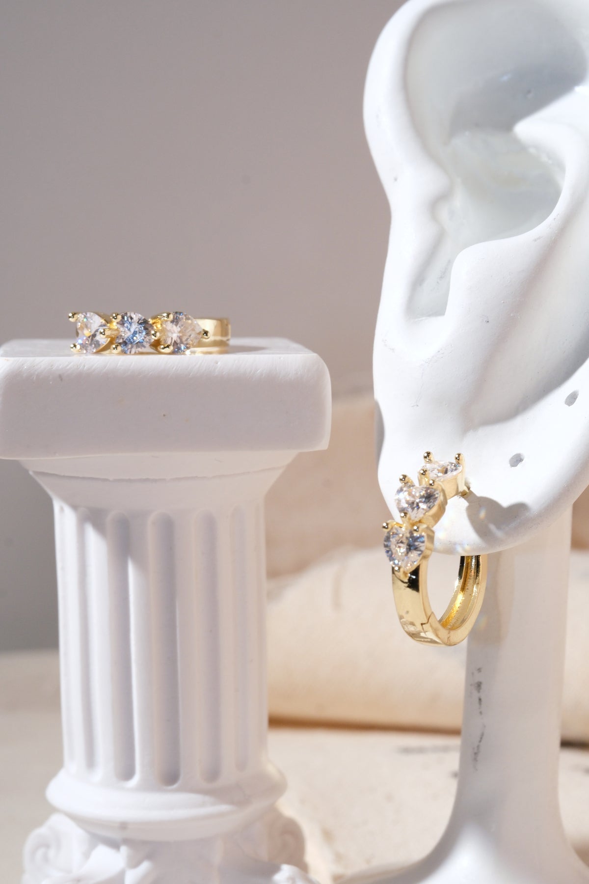 Gold Triple Heart CZ Huggie Earrings — edited real product photo