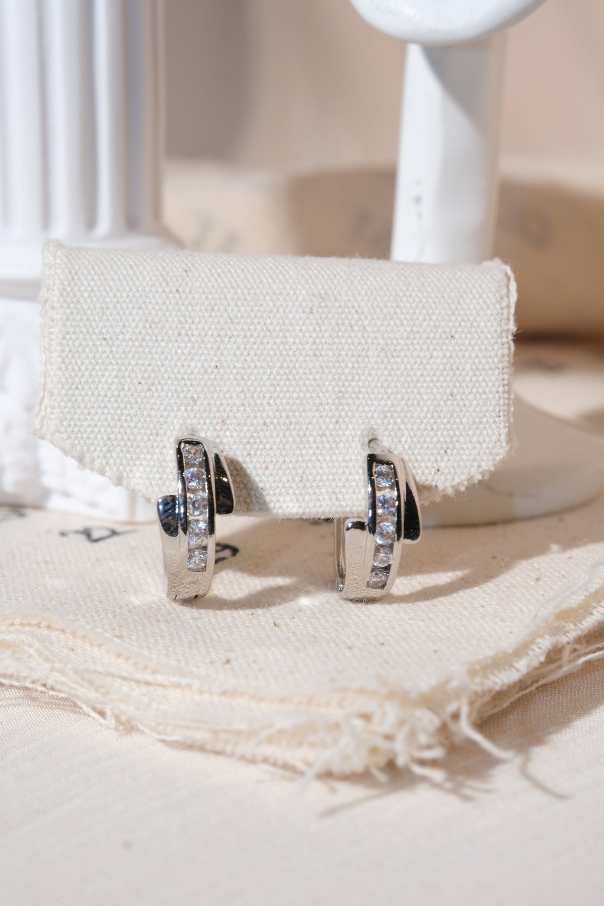 Silver Crossover CZ Huggie Earrings — edited real product photo