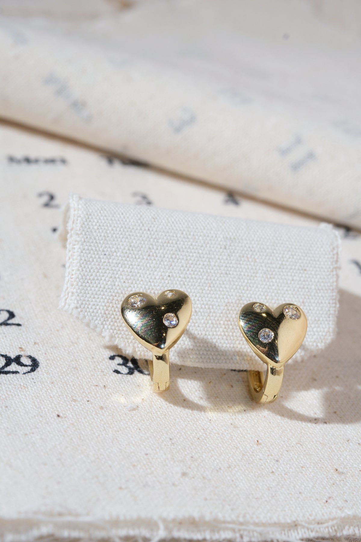Gold Scattered CZ Heart Huggie Earrings — edited real product photo