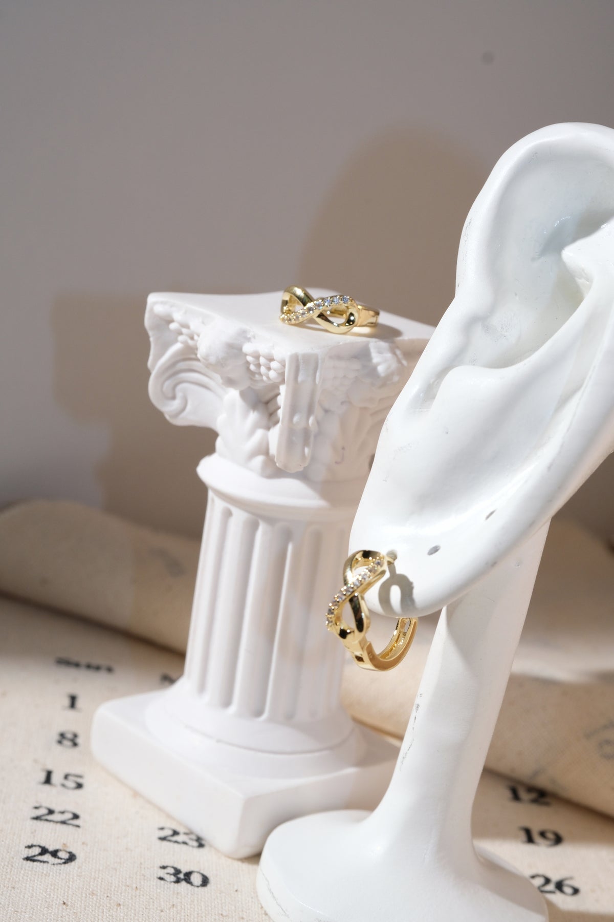 Gold Infinity CZ Huggie Earrings — edited real product photo