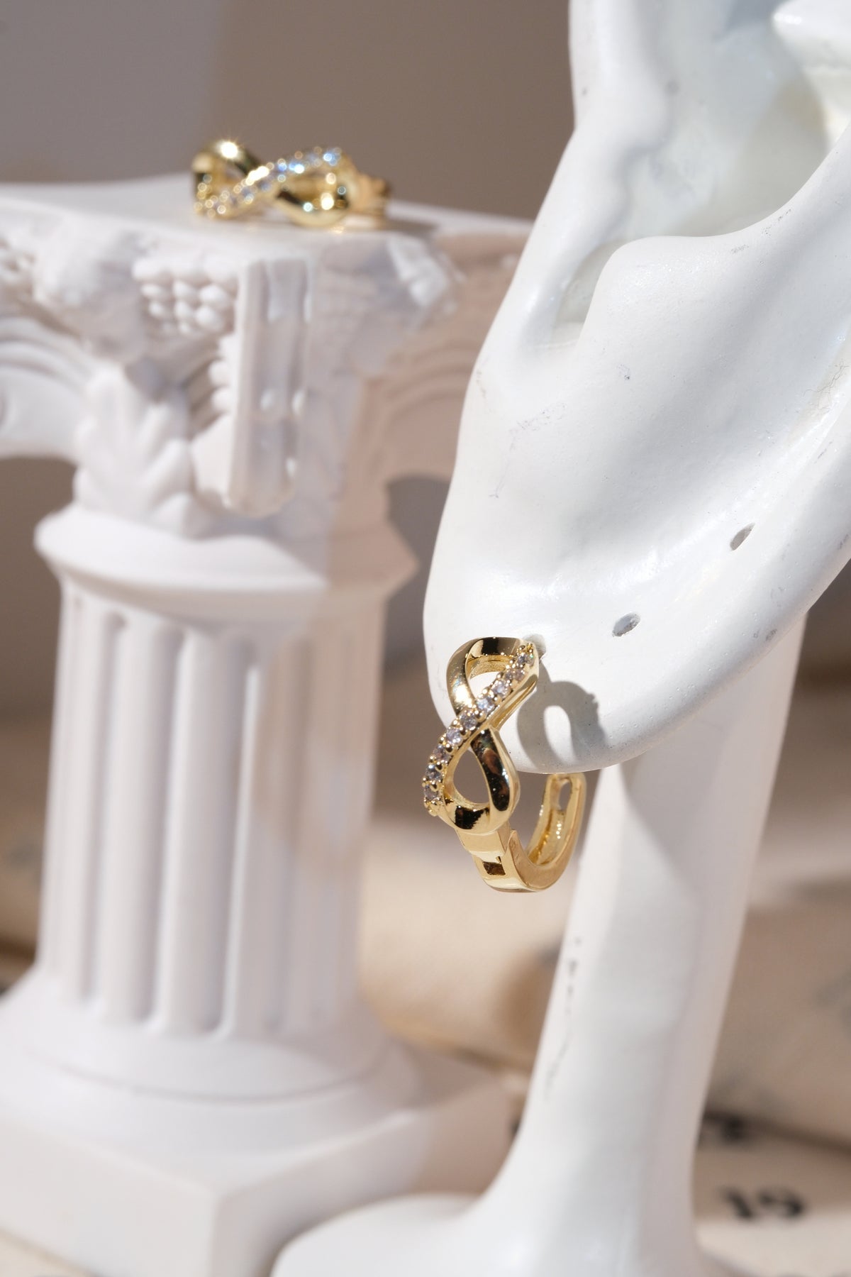 Gold Infinity CZ Huggie Earrings — edited real product photo