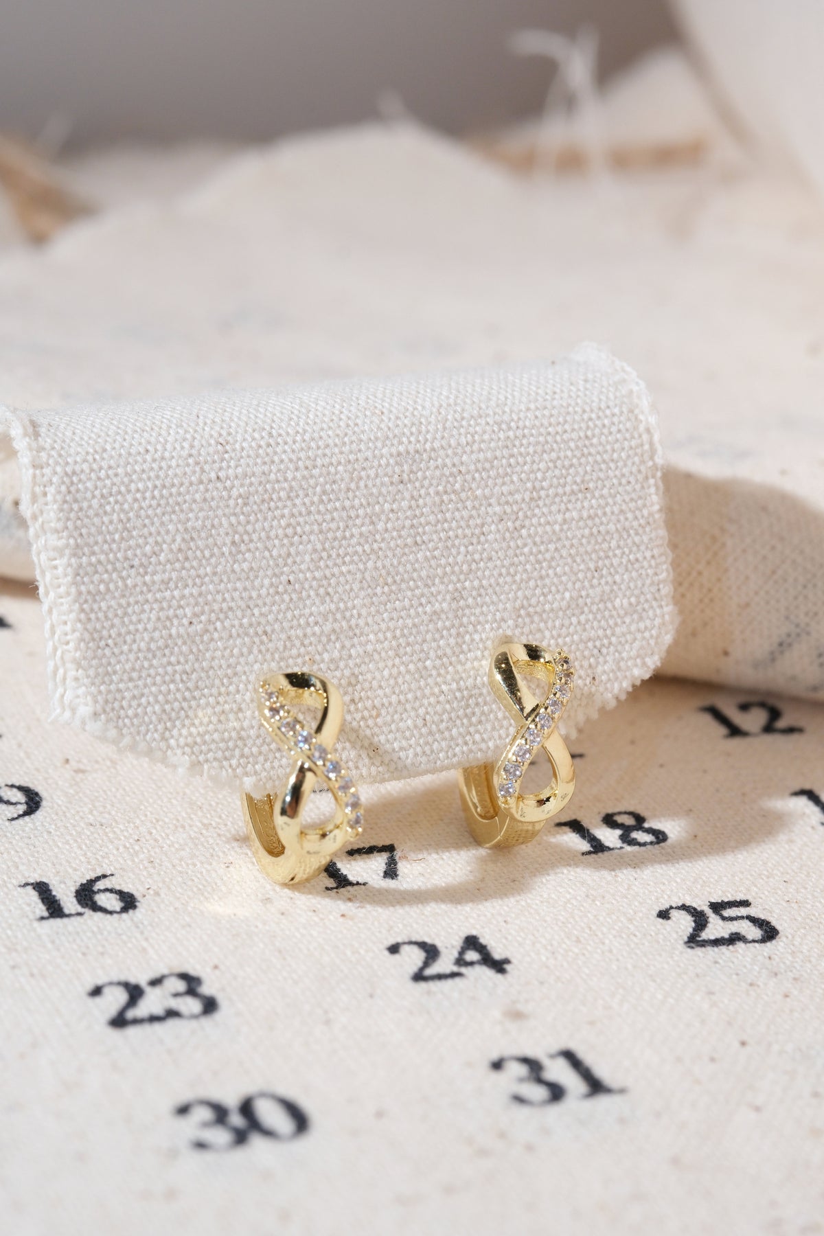 Gold Infinity CZ Huggie Earrings — edited real product photo