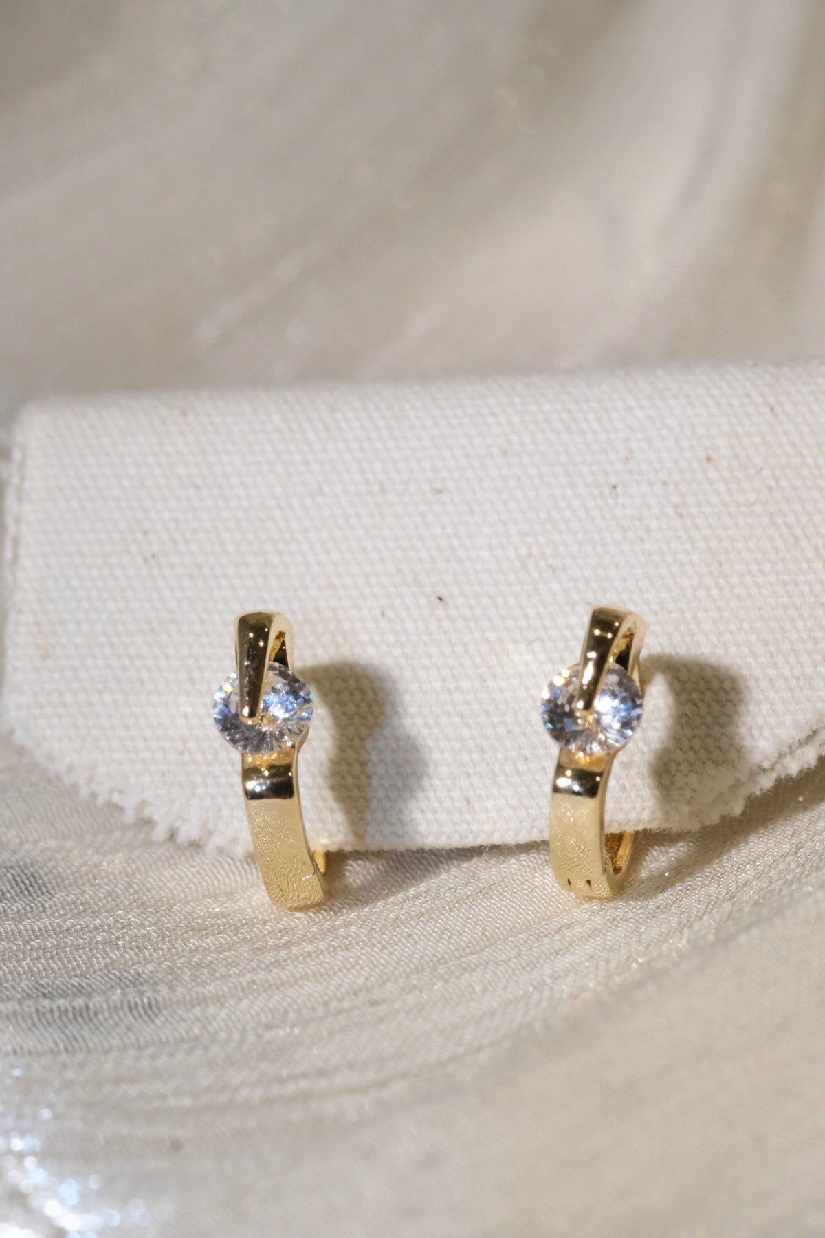 Solitaire CZ Huggie Earrings — Gold — edited real product photo