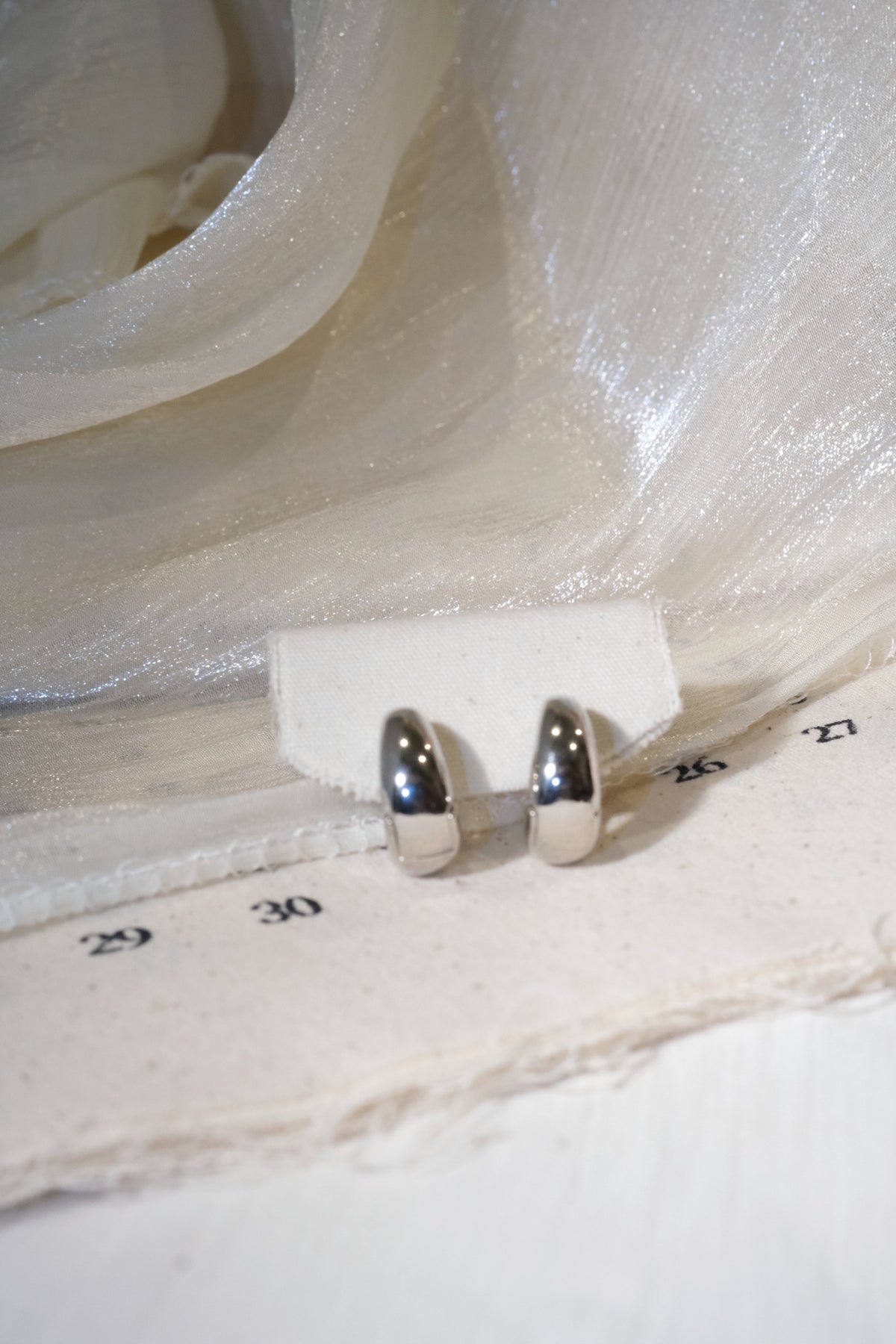 Rounded Huggie Earrings — Silver — edited real product photo
